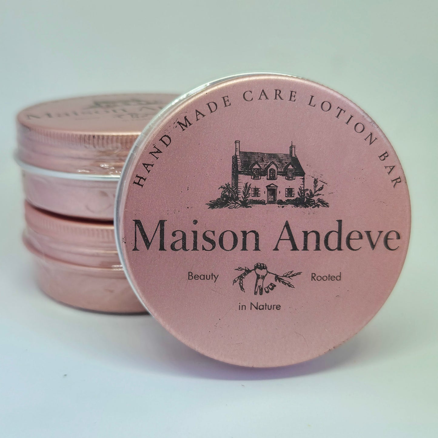 Stack of Maison Andeve Blushing Rose lotion bars in pink tins, natural solid skincare product for dry skin