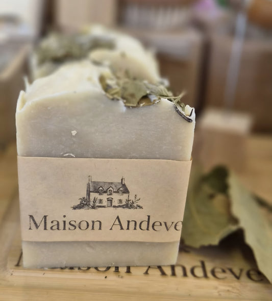 Close up of Maison Andeve botanical soap bar topped with dried leaves, natural handmade skincare product