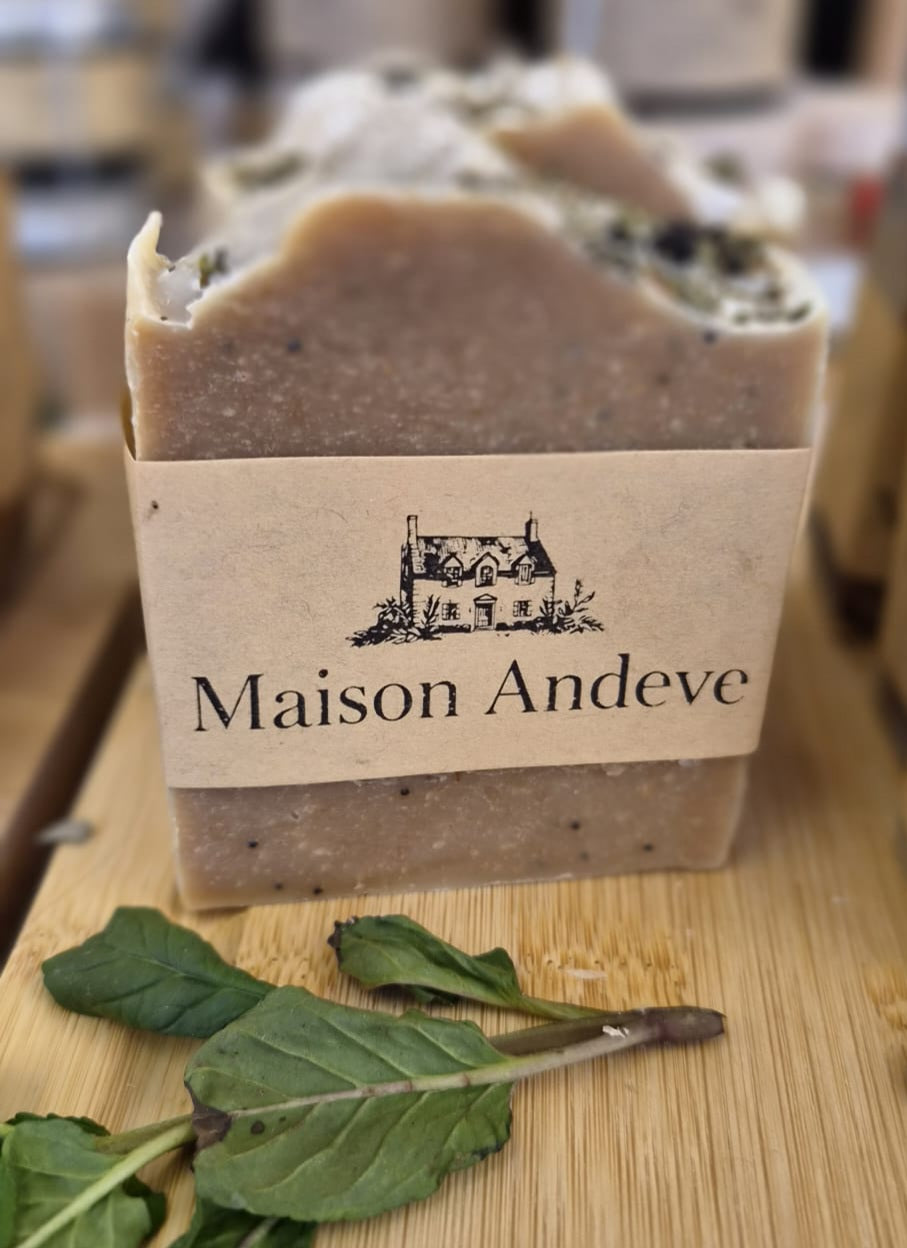 Close up of Maison Andeve handmade herbal soap bar with natural ingredients on wooden surface