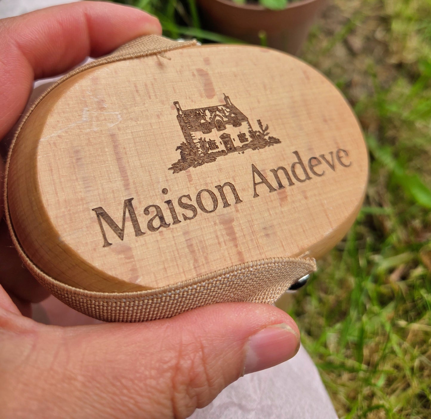 Maison Andeve wooden dry brush with engraved logo held in hand outdoors, natural body brush for exfoliation and lymphatic drainage
