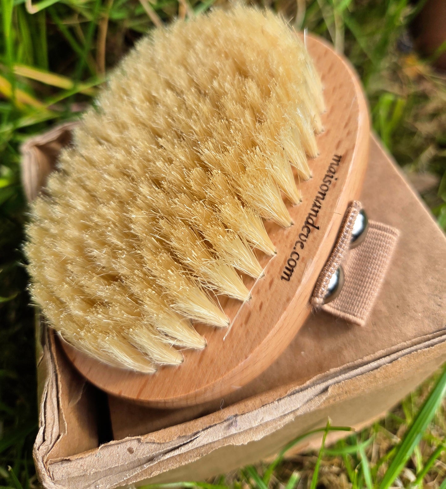 Maison Andeve wooden dry brush with natural bristles placed on box outdoors, eco friendly body brush for exfoliation and lymphatic drainage